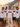 JGA Crew mit Braeutigam in Retro-Regenbogen-Shirts vor Positano im goldenen Abendlicht