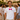 Bräutigam im weißen JGA Shirt mit pinker Fliege lacht beim Junggesellenabschied mit Freunden