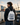 Person mit Fischmarkt-Hamburg-Turnbeutel am Hafen – Aufdruck FISCHMARKT HAMBURG